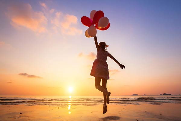 beach-girl-balloons-iStock-636341574-flip@600w